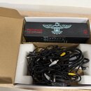 Černý napájecí adaptér s nápisy PHOENIX CLEAN POWER a HANDMADE IN THE USA, doplněný bílým logem ptáka. V krabici s polystyrenovými vložkami se nacház…