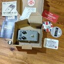 Šedý kytarový efekt v kartonové krabici s nápisem British Pedal Company na boku. K pedálu patří dokumentace, červená varovná lišta a dvě nálepky, z n…