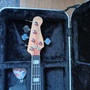Hlava a hриф basové kytary v černém tvrdém kufru. Na hlavě je nápis Marcus Miller a jsou vidět čtyři ladicí mechanismy. K nástroji je přiložen černý…