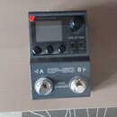 Šedý efektový procesor s dvěma stoupacími spínači. Na přístroji jsou nápisy „GP-50“, „TUNER“, „HOLD FOR LOOPER“ a značka „VALETON“. Zařízení obsahuje…