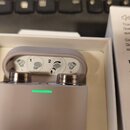 Bílé bezdrátová sluchátka v nabíjecím pouzdře. Na sluchátkách je vidět nápis Bowers & Wilkins a označení L a R. Pouzdro má na přední straně svítící z…
