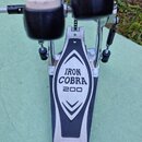 Krytý pohled na basový pedál s dvěma černými beatery. Na stálkovém plátku je černý trojúhelníkový design s bílým nápisem IRON COBRA 200 a v dolní čás…