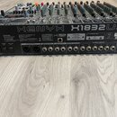 Černý mixážní pult s nápisy XENYX a X1832USB. Na levé straně je logo a značka behringer, vpravo je čárcový kód s číslem S1800711040K a Date Code 1606…