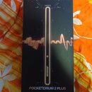 Černá krabice s produktovou fotografií elektronického nástroje. Na krabici je nápis Aeroband a v dolní části text POCKETDRUM 2 PLUS. Povrch krabice j…