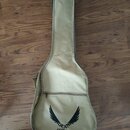 Béžový softcase na kytaru z textilního materiálu. Ve spodní části je černý potisk s logem křídel a nápisem DEAN GUITARS. Povrch obalu vykazuje mírné…