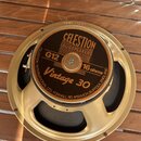 Fotografie znázorňuje reproduktor v zlatavém kovovém rámu. Na středovém štítku je uveden nápis CELESTION LOUDSPEAKERS, model G12 Vintage 30 a impedan…