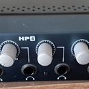Černý distribuční zesilovač sluchátek s pět vệmi stříbrnými ovládacími knoflíky. Na předním panelu jsou nápisy PreSonus a HP4, u posledního knoflíku…