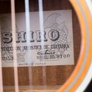 Detail vnitřku kytary s papírovým štítkem. Na štítku je velký nápis SHIRO, pod ním text CONSTRUCCION ARTISTICA DE GUITARRA a MODEL NO. 9100. Dole je…