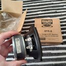 Fotografie znázorňuje černý reproduktor s kovovým magnetem, který drží ruka. Na magnetu je štítek s logem GRS a nápisy 4FR-8, 8 OHM, MADE IN CHINA. V…