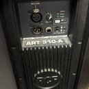 Zadní panel černého aktivního reproduktoru. Je zde vidět nápis ART 310-A a logo RCF. Panel obsahuje dva XLR konektory, ovratový regulátor VOLUME, pře…