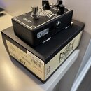 Černý kytarový efekt s nápisem DELAY a logem ECHOPLEX. Na boku je vidět vstup INPUT, značka CE a piktogramy napájení. Efekt stojí na kartonové krabic…