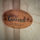 Detailní záběr na oválný štítek uvnitř akustického nástroje. Štítek obsahuje modré logo CRAFTER, nápisy HANDCRAFTED TO BE THE BEST™, SINCE 1972 a MAD…