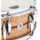 Detailní pohled na snare drum s korusem v bílé barvě. Korpus je vyroben ze světlého dřeva s výraznou strukturou a tmavým vodorovným pruhem, doplněn c…