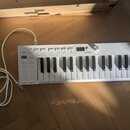 Bílá klávesová kontrola s nápisem KEYSTEP v pravém horním rohu a logem ARTURIA uprostřed. Nástroj má bílé klávesy, černé hrací klávesy a řadu ovládac…