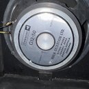 Fotografie zachicuje zadní stranu reproduktoru s kovovým rámem. Na středovém štítku je uveden název značky Celestion a model G12-50 s impedancí 8 ohm…