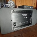 Zadní strana šedého studiového monitoru s kovovým zadním panelem. Na panelu je bílý nápis ADAM AUDIO Berlin, Germany a Model S3H. Jsou zde viditelné…