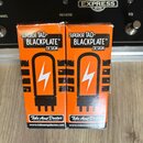 Dvě oranžové krabičky s nápisy SUPERIOR TAD-BLACKPLATE™ DESIGN a logem Tube Amp Doctor. Na krabicích je zobrazen bílý symbol blesku uvnitř stylizovan…