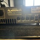 Zadní strana černého zesilovače značky Ampeg. Jsou zde viditelné konektory s popisky POWER AMP IN, PREAMP OUT, RETURN, SEND a BAL. OUT, přičemž u pos…