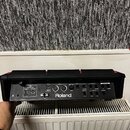 Zadní strana černého elektronického zařízení značky Roland. Jsou zde vidět různé konektory a popisky: HI-SPEED USB (MEMORY, COMPUTER), DC IN, MIDI (I…