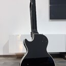 Zadní strana černé elektrické kytary s bílým lemováním hran. Na zadní straně těla je vidět nápis „Epiphone“ a pod ním logo v podobu kosočtverce s náp…