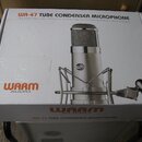 Bílá kartonová krabice s produktovou fotografií mikrofonu v pavoukovém držáku. Na krabici je nápis WA-47 TUBE CONDENSER MICROPHONE a logo WARM AUDIO.…