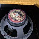 Kytarový reproduktor s šedým kovovým rámem. Na zadní straně je štítek s nápisy WAREHOUSE, ET65, BRITISH INVASION, 16 OHM a 65 WATTS. Štítek obsahuje…
