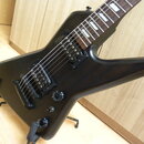 Černá elektrická kytara s tmavým hmatníkem a bílými vložkami. Nástroj má dva humbuckery, jeden ovládací knoflík a přepínač. Kytara je umístěna v čern…