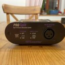 Černý kovový mikrofonní splittery s nápisy PRO Split a High Performance Microphone Splitter. Na předním panelu jsou přepínače GROUND LIFT a INPUT PAD…