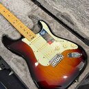 Elektrická kytara s t bodies v barevném přechodu od černé přes červenou k žluté a se světlým hmatníkem. Na těle je bílý pickguard, tři snímače a nápi…