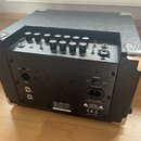 Černý basový kombozesilovač s texturovaným povrchem a chromovanými rohy. Na zadním panelu jsou konektory DI OUT, FOOT SWITCH a AC-INPUT, přepínač POW…