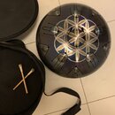 Kovový perkusní nástroj ve tvaru koule s tmavě modrým přechodem do černé barvy. Na horní části je vyveden geometrický vzor v podobě bílých a zlatavýc…