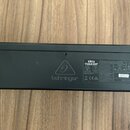 Černý digitální mixér s nápisem behringer a označením modelu XR12. Na zadní straně je vidět bílá štítková nálepka s technickými parametry, bezpečnost…