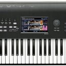 Černý digitální klavír s bílými a černými klávesami. Na levé straně je bílý nápis KORG a na pravé straně nápisy NAUTILUS MUSIC WORKSTATION. Uprostřed…