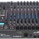 Černý mixovací pult s řadou posuvníků a ovládacích knoflíků v modré, červené a šedé barvě. Na spodním panelu je nápis the t.mix a model XMIX 1402FX M…