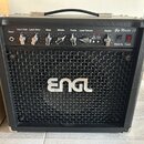 Černý kytarový kombozesilovač s kovovou mřížkou a logem ENGL uprostřed. Na horním ovládacím panelu jsou nápisy Input, Input Gain, Lead Drive, Bass, M…