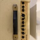 Detail ovládacího panelu zesilovače v krémovém provedení s černou plastovou rukojetí. Na panelu je nápis Acoustic Regent 30 a logo Epiphone. Jsou zde…