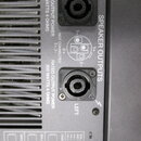 Detail zadní strany zesilovače s dvěma konektory SPEAKER OUTPUTS označenými jako RIGHT a LEFT. U obou výstupů je uveden nápis RATED OUTPUT POWER 300…