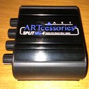 Černý kovový box s nápisy ARTccessories™ a SPLIT Mix 4 Passive Four Channel Mixer / Splitter. Na horní části je rovněž uveden nápis ART. Z levé stran…