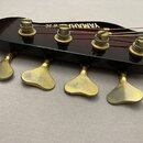 Černá hlava basové kytary s čtyřmi zlatými ladičkami. Na povrchu je bílý nápis YAMAHA. Zlatý povrch ladiček vykazuje viditelné opotřebení a oděrky.