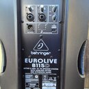 Zadní panel černého aktivního reproduktoru značky behringer, model EUROLIVE B115D. Panel obsahuje dva vstupní kanály s ovladači LEVEL, jeden ovladač…