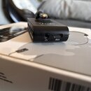 Černý kompaktní kytarový zesilovač s nápisem Fender MUSTANG MICRO. Na zadní straně jsou umístěny dva konektory, jeden s ikonou sluchátek a druhý s ik…