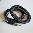 Černý pletený instrumentní kabel s bílými protkanými vlákny. Na konektorech jsou viditelné nápisy whirlwind LEADER. Konektory mají zlatavý povrch a č…