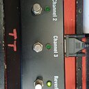 Černý nožní spínací pedalboard značky Laney s pěti tlačítky a zelenými kontrolkami. Na přístroji jsou nápisy Channel 1, Channel 2, Channel 3, Reverb…