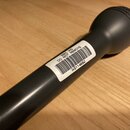 Černý dynamický mikrofon s kovovou mřížkou. Na těle je nalepená bílá nálepka s čárovým kódem a nápisy BBC WIS, DO NOT REMOVE a WS114682. Povrch mikro…