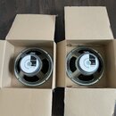 Dvě jednotky reproduktorů v hnědých kartonových krabicích. Na středovém krytu obou reproduktorů je bílý štítek s nápisy CELESTION, G12T-75 a textem v…