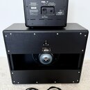 Zadní strana černého komba a reproduktorové skříně. Na horním zařízení je nápis MODEL: VGS 15 a logo Blackstar s textem Blackstar Amplification Ltd.…