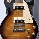 Elektrická kytara s tmavě hnědým gradientem (sunburst) a viditelnou strukturou dřeva na topu. Nástroj má dva humbuckery s krémovými rámečky, krémový…