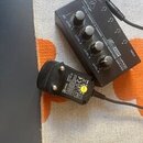 Černý rozdělovač sluchátek s nápisy „behringer“, „ULTRA-COMPACT 4-CHANNEL STEREO HEADPHONE AMPLIFIER“ a „HA400 AMP“. Zařízení má čtyři ovládací knofl…