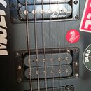 Černá elektrická kytara s dvěma humbuckery. Na horním snímači je bílý nápis Jackson, vedle snímačů je červený kulatý nálepka s nápisem HONDA. Tělo ky…