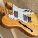 Elektrická kytara s polodupatým tělem z přírodního dřeva s viditnou masivní strukturou a lakovaným povrchem. Nástroj má bílý perleťový pickguard, dva…